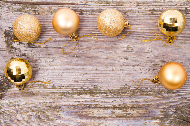 Ahşap bir zemin üzerine altın Noel topları - Fotoğraf, Görsel