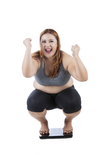 Happy woman squat on weight scale  - Фото, зображення