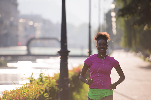 african american woman jogging in the city - 写真・画像
