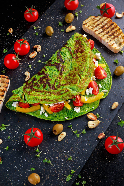 Zeleninová omeleta zelené s řecký sýr, olivy, rajčata, paprika, ořechy připít na kamenné pozadí. pojem zdravé jídlo. - Fotografie, Obrázek