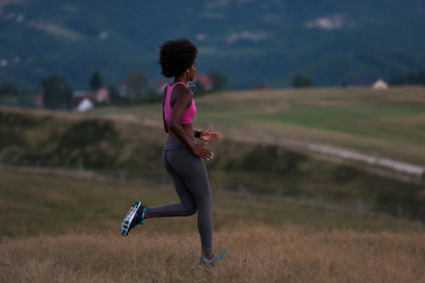 Young African american woman jogging in nature - 写真・画像