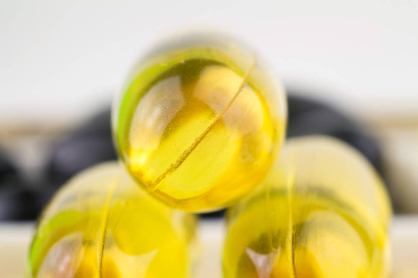 Természetes étrend-kiegészító, sárga gél tabletta, a zsírsavak omega-3 kapszula halolaj, makro-kép. - Fotó, kép