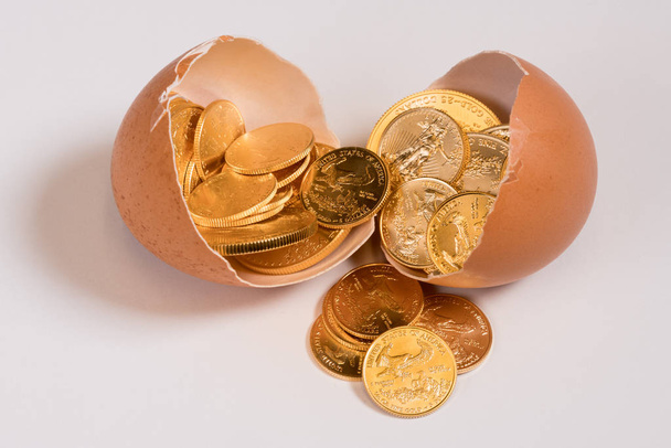 Pure złote monety w egg shell ilustrujące nest egg - Zdjęcie, obraz