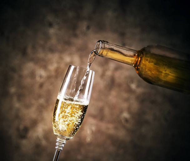 White wine pouring into a glass - Zdjęcie, obraz