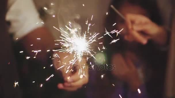 Bliska rodzina ręce ze światłami ognie w Wigilię Bożego Narodzenia - Materiał filmowy, wideo