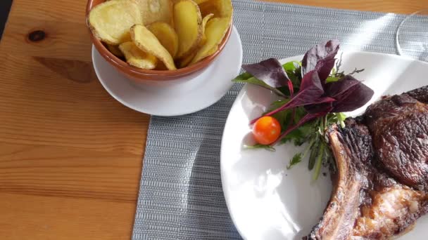 Μοσχαρίσια μπριζόλα σε ένα πιάτο με σαλάτα και πατάτες  - Πλάνα, βίντεο