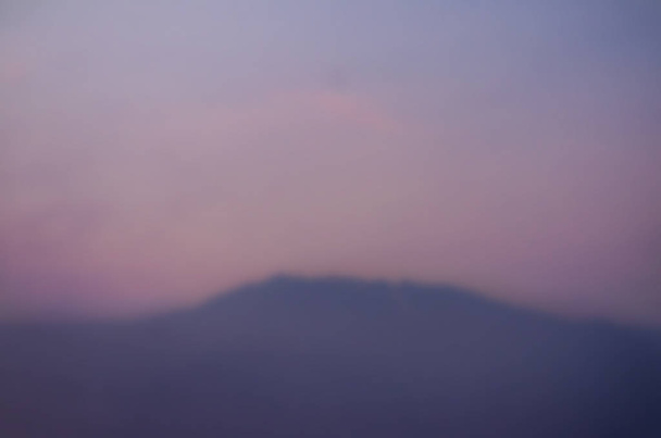 verschwommene Gebirgslandschaft mit farbigem Himmel bei Sonnenuntergang - Foto, Bild