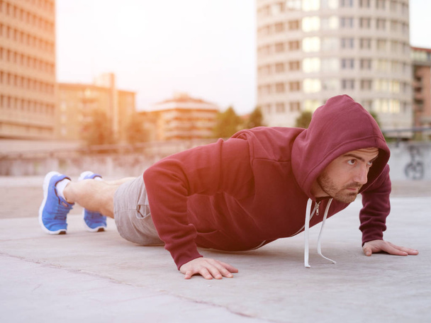 young adult sportsman working out in the city - Photo, Image