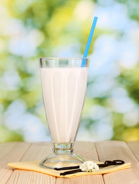 Vanilla milk shake on wooden table on bright background - Фото, зображення