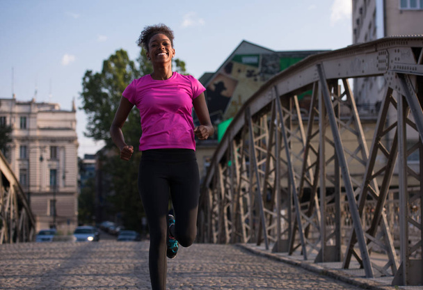 african american woman running across the bridge - Fotoğraf, Görsel
