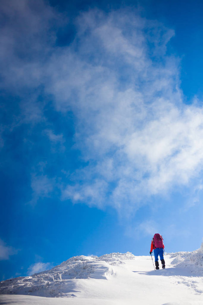 Girl with backpack walking on snow in the mountains. - Fotó, kép