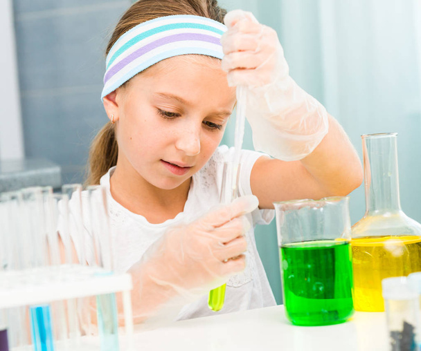 little girl with flasks for chemistry - Foto, afbeelding