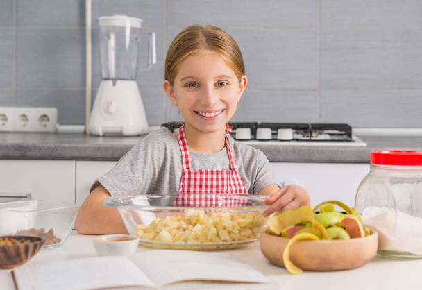 little girl with cut apples in bowl - Фото, зображення
