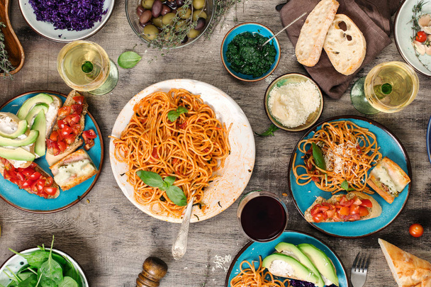 Italian pasta with tomato sauce with snacks and wine - Фото, изображение