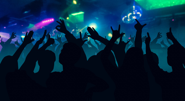 Siluetas de personas bailando delante de luces de escenario brillantes
 - Foto, Imagen
