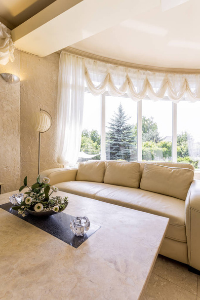 Salón blanco con sofá y ventana panorámica
 - Foto, Imagen