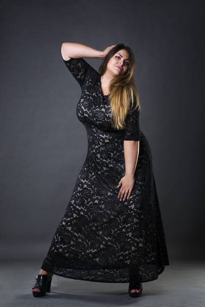 Young beautiful plus size model in black dres, xxl woman on gray studio background - Foto, Imagem