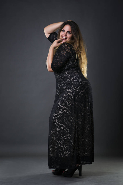 Young beautiful plus size model in black dres, xxl woman on gray studio background - Valokuva, kuva