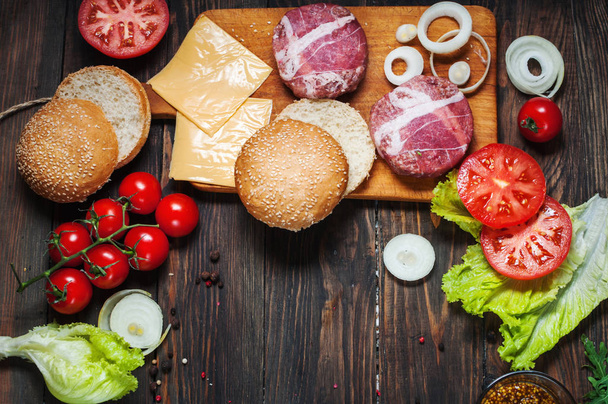 Ingredients for making homemade burger on wooden cutting board - Foto, afbeelding