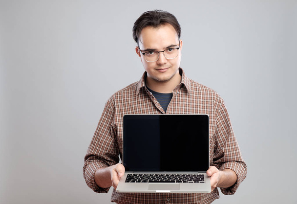 Man holding and showing laptop computer - Fotó, kép