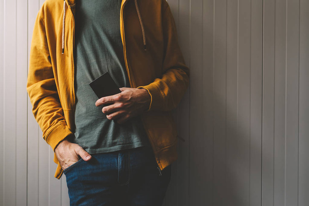 Casual young adult man posing with mobile phone in hand - Foto, Imagem