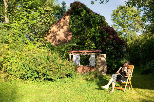 жінка читає книгу в саду
 - Фото, зображення