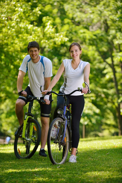 Happy couple riding bicycle outdoors - Fotoğraf, Görsel