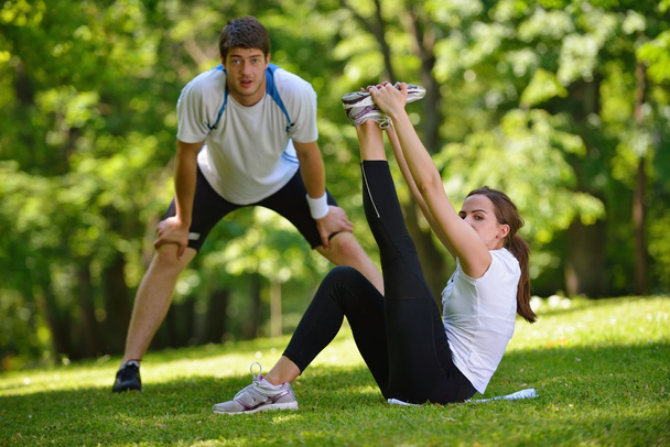 Couple doing stretching exercise after jogging - Фото, зображення