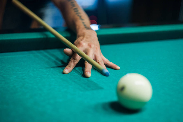 Billiard balls in a green pool table, game. Table for billiards with balls.Hand with billiard ball close up - Photo, Image