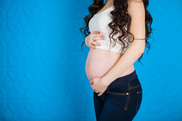 Close up Pregnant woman on blue background - 写真・画像