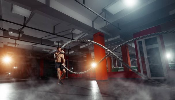 Fitness man working out with battle ropes at a gym - Foto, Imagem