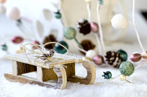 Trineo de madera con nieve, guirnalda de Navidad y carro
 - Foto, imagen