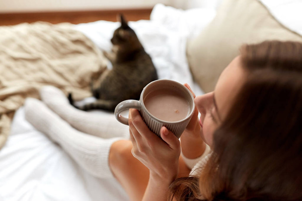 закрыть глаза на счастливую женщину с чашкой кофе дома
 - Фото, изображение