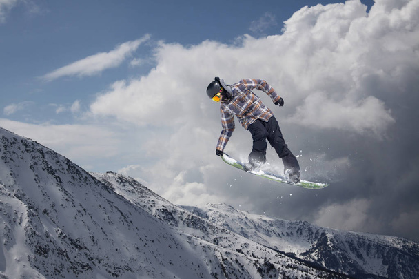 Snowboard rider saltando en las montañas. Extremo snowboard freeride sport. - Foto, Imagen