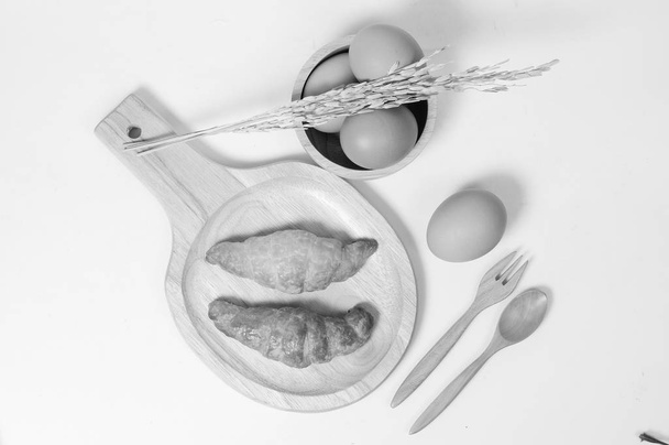 Croissant doppi e uova fresche con articoli in legno
  - Foto, immagini