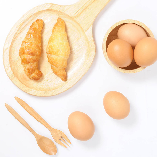 Cruasanes dobles y huevos frescos con artículos de madera
  - Foto, Imagen