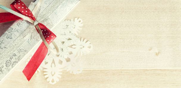 Warm filtered gift and paper snowflakes on wood. Christmas siver - Fotoğraf, Görsel
