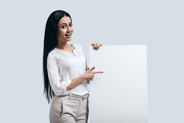 Woman pointing on blank flipchart - Foto, afbeelding