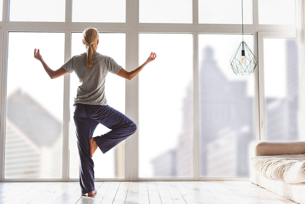 Relaxed young woman exercising at home - Photo, image