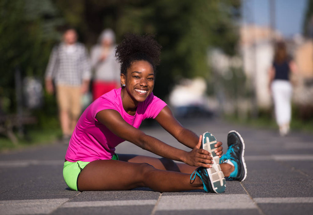 sporty young african american woman stretching outdoors - Fotografie, Obrázek