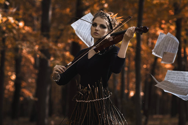 Молода красива жінка грає на скрипці над літаючими нотами
 - Фото, зображення
