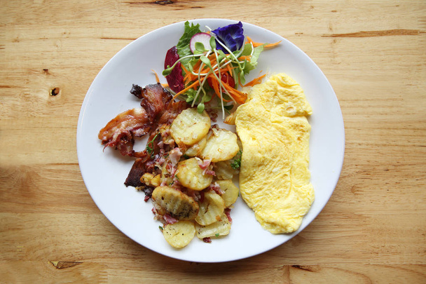 A delicious home style breakfast with crispy bacon, eggs omelett - Foto, afbeelding