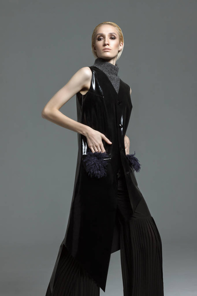 Divat fotózás. Fekete Designer ruha a stúdióban egy szürke háttér. Lány-szőke raslablennoy jelent. Ruha reklám. - Fotó, kép
