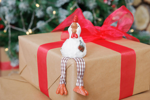 the symbol of the new 2017 rooster on the background of Christmas tree and boxes with gifts - Fotoğraf, Görsel