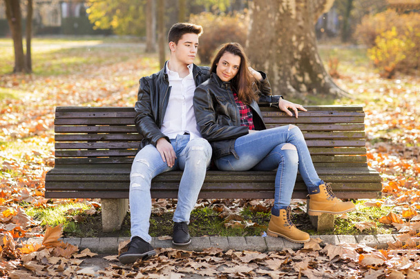 Happy young couple sitting on a bench in the park - Foto, immagini