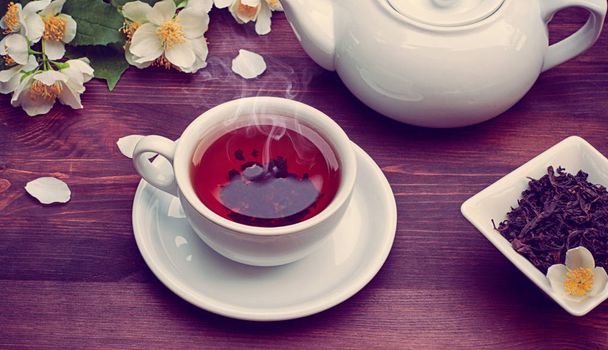 Hot black tea in a cup and saucer, vintage toning - Foto, Imagen