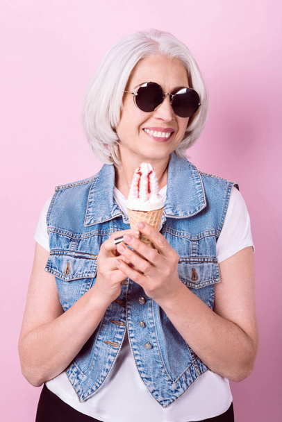 Smiling stylish woman holding an icecream. - Fotó, kép