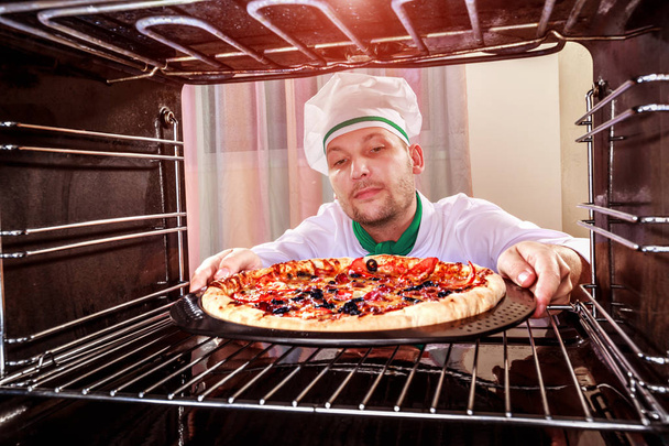 Chef cooking pizza in the oven. - Photo, image