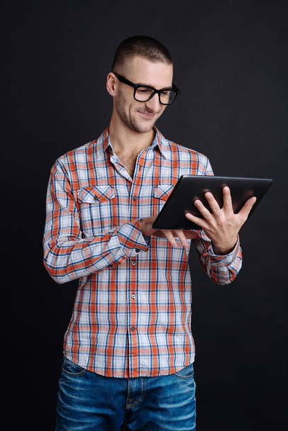 Smiling man while working with the tablet computer - Photo, image