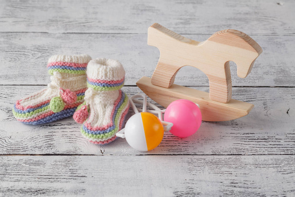 Newborn announcement template. Handmade knitted booties with toy - Foto, Imagen